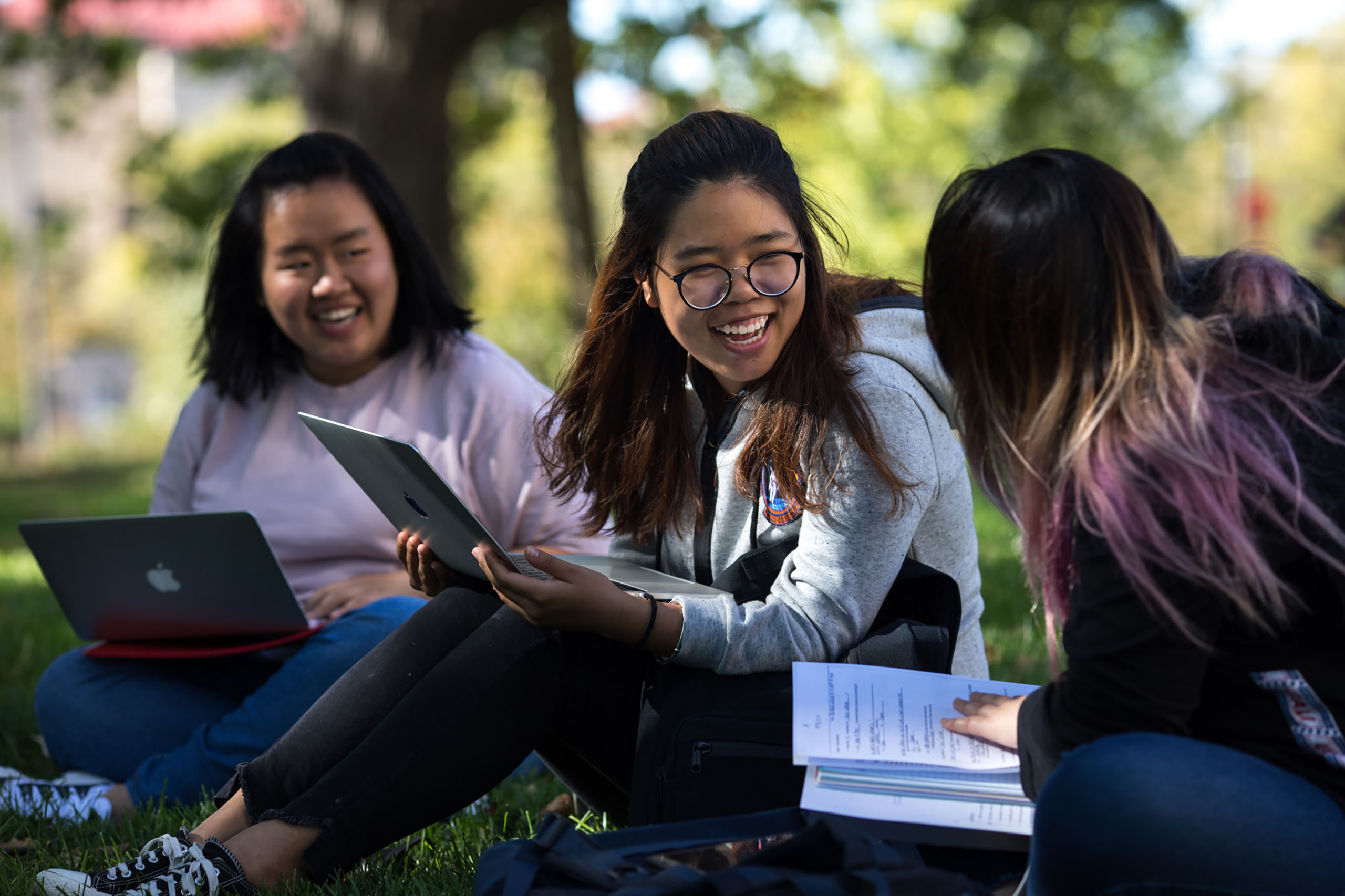 A group of students sits outside