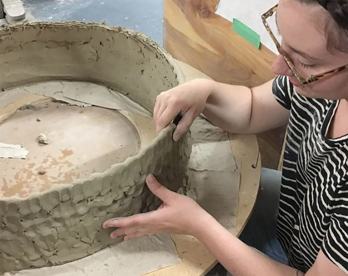 A student works on a large pot