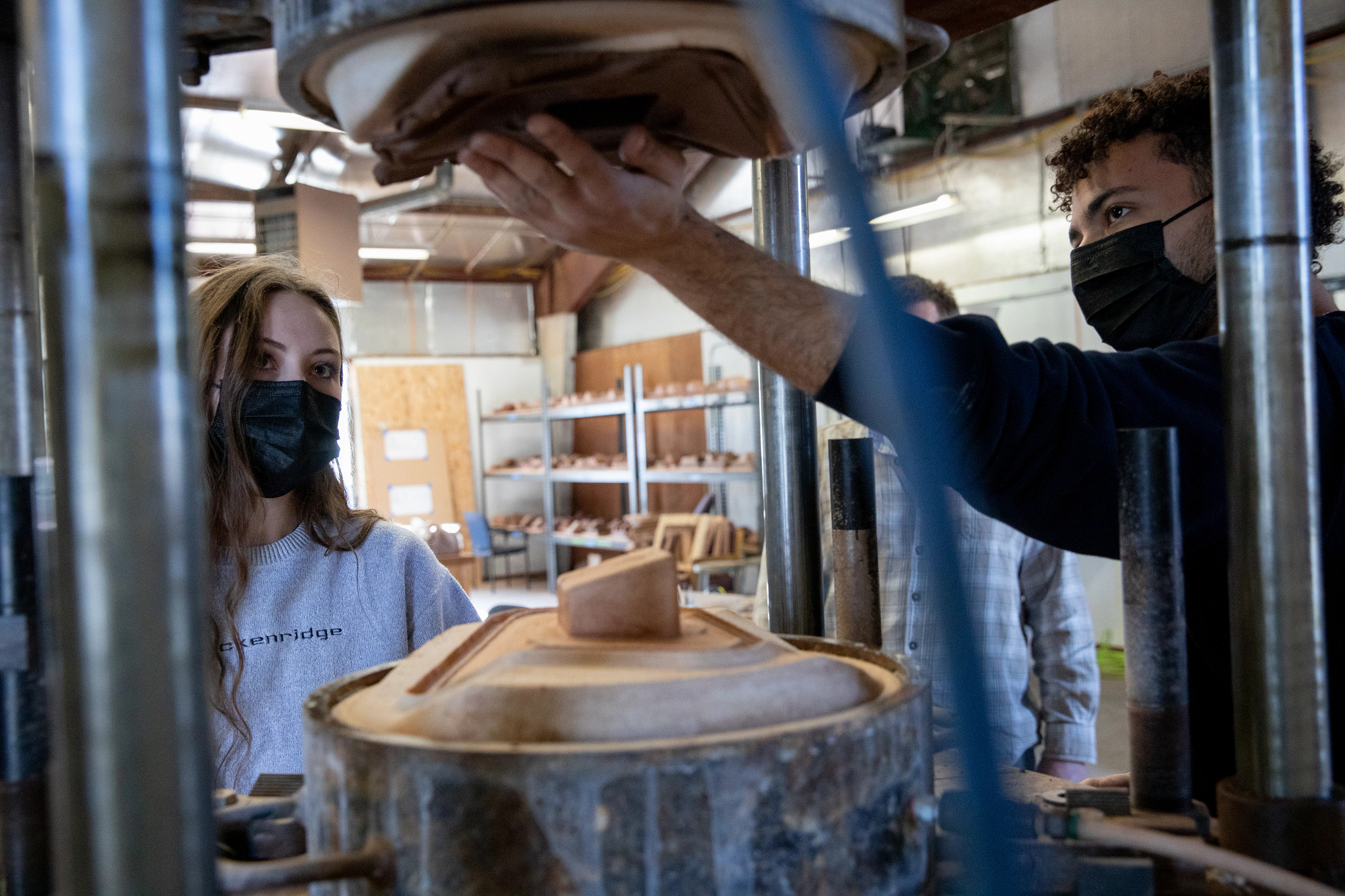 Two students use a ceramic press