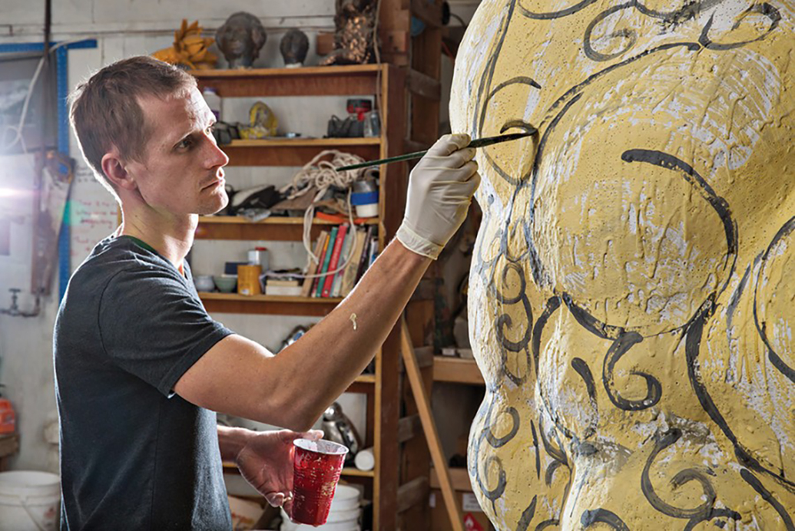 Matt Wedel painting a large ceramic piece