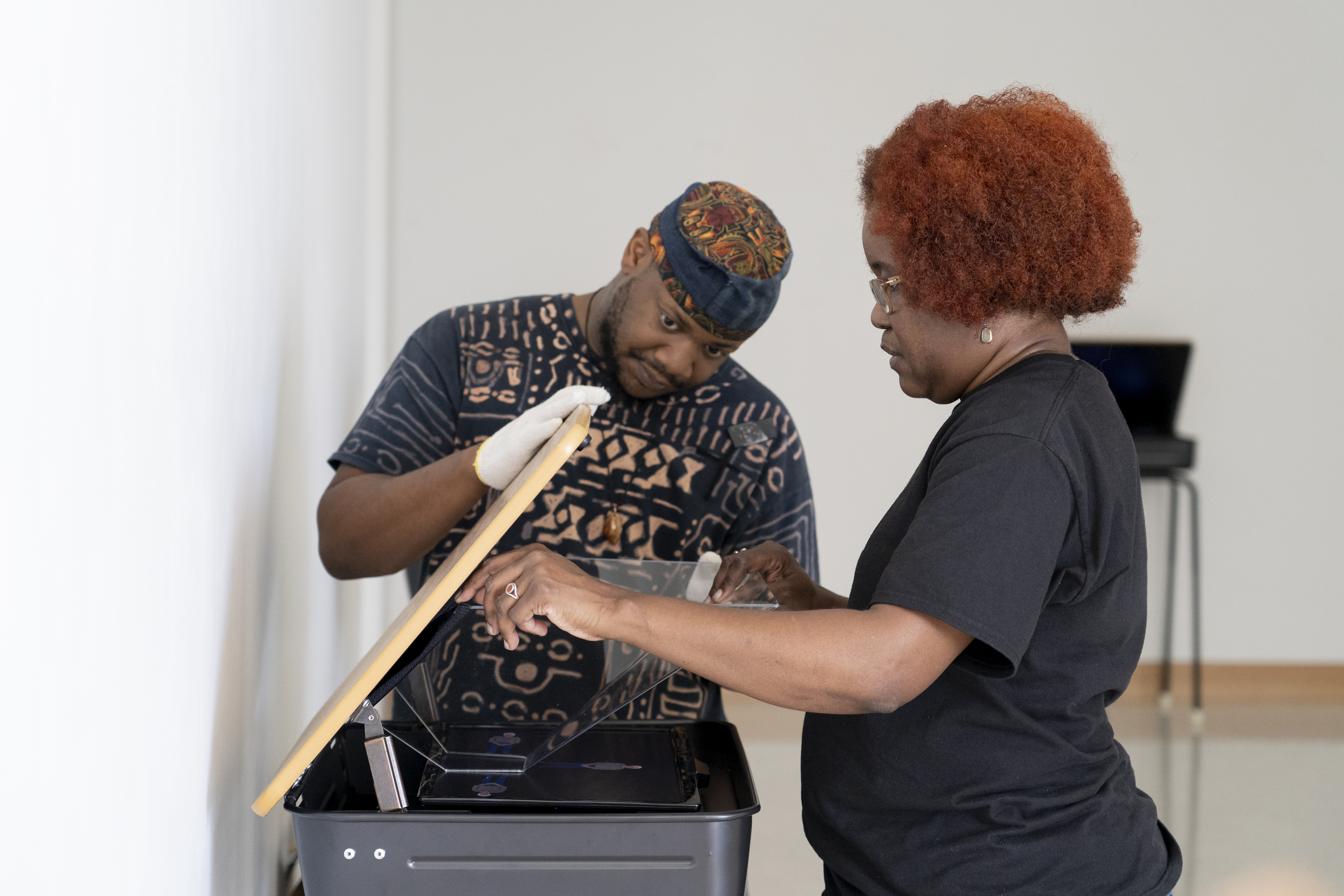 A Student helps an artist arrange a sculpture