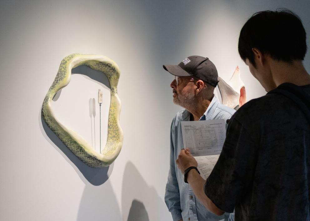 Two people looking at wall work